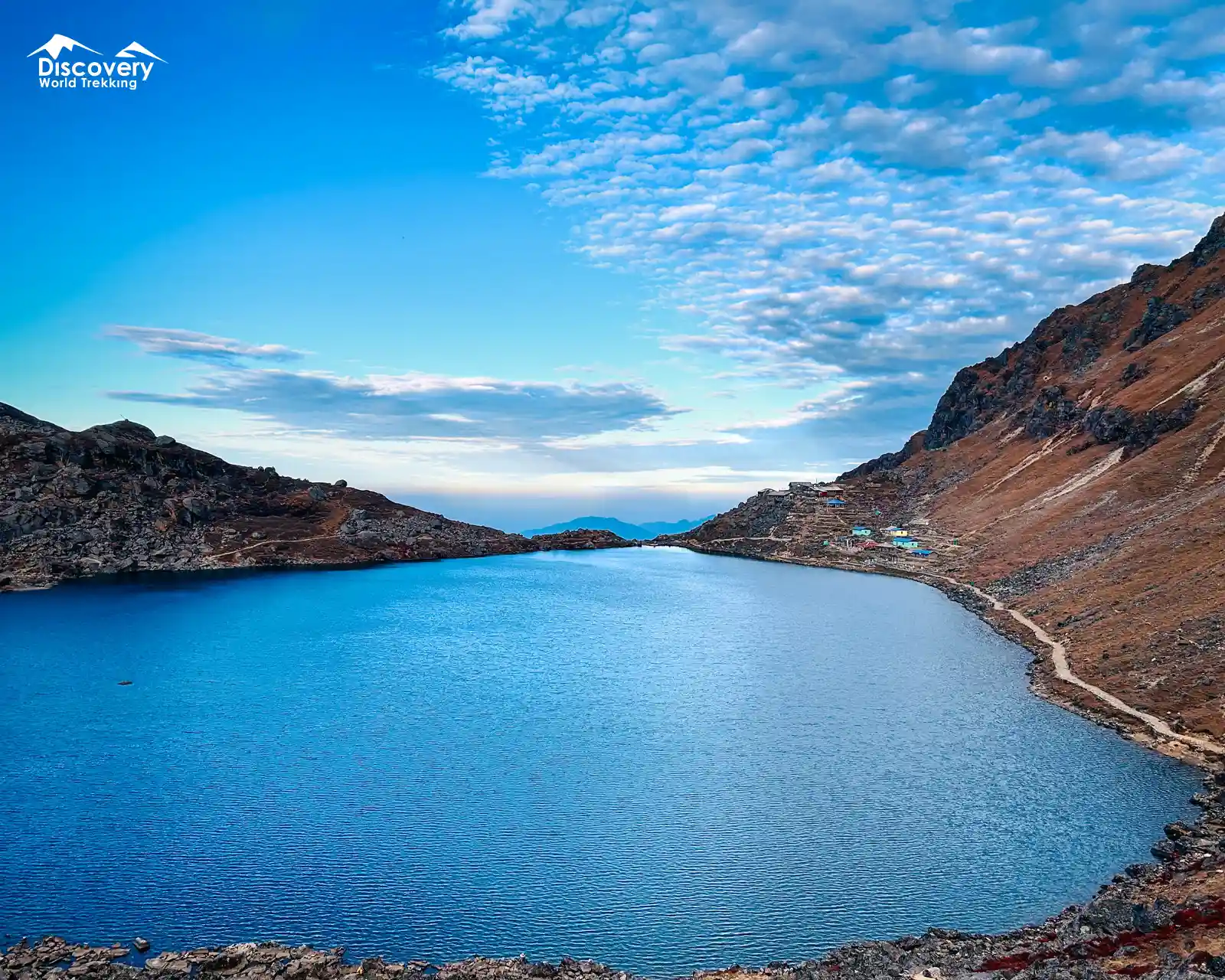 Stunning turquoise Gosainkunda Holy Lake surrounded by rugged rocky mountains.