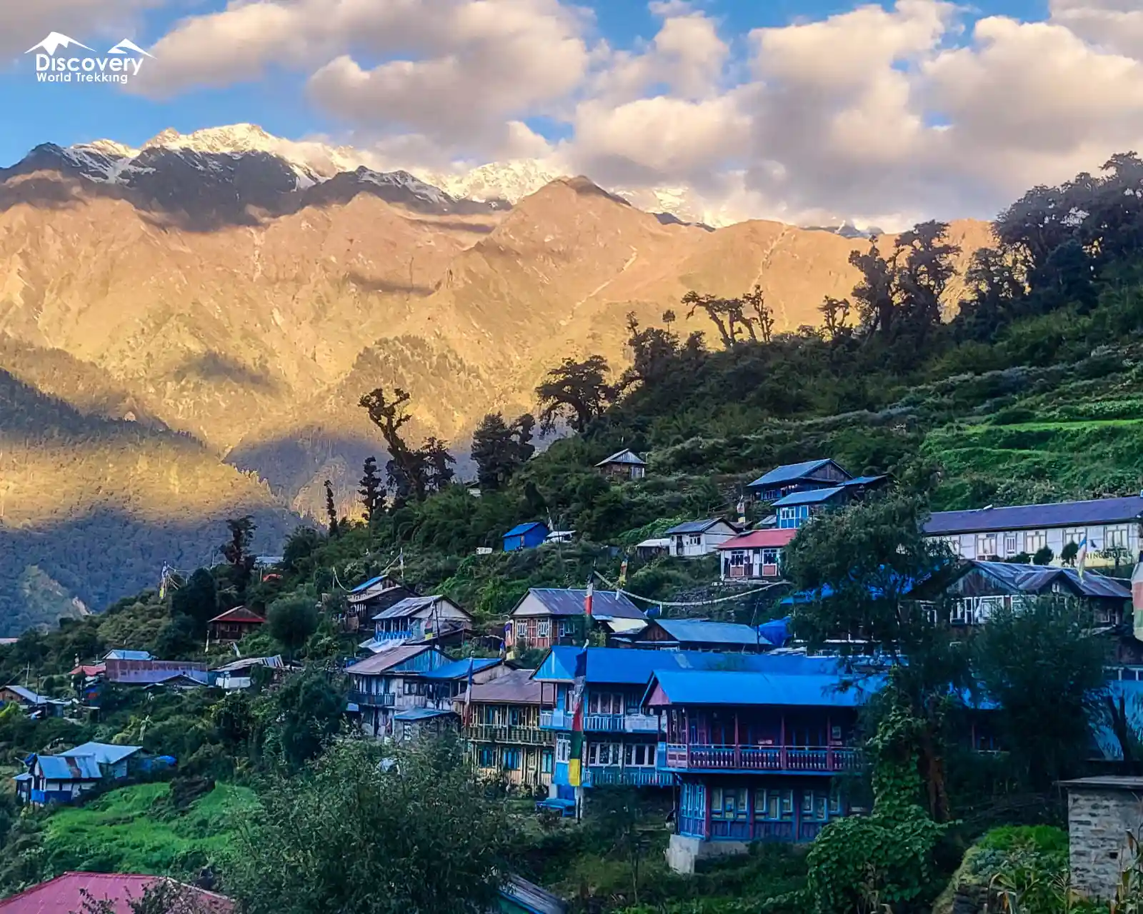 Tatopani village on the Langtang Gosainkunda Lake trek, nestled on lush terraced hillsides with vibrant blue-roofed houses.