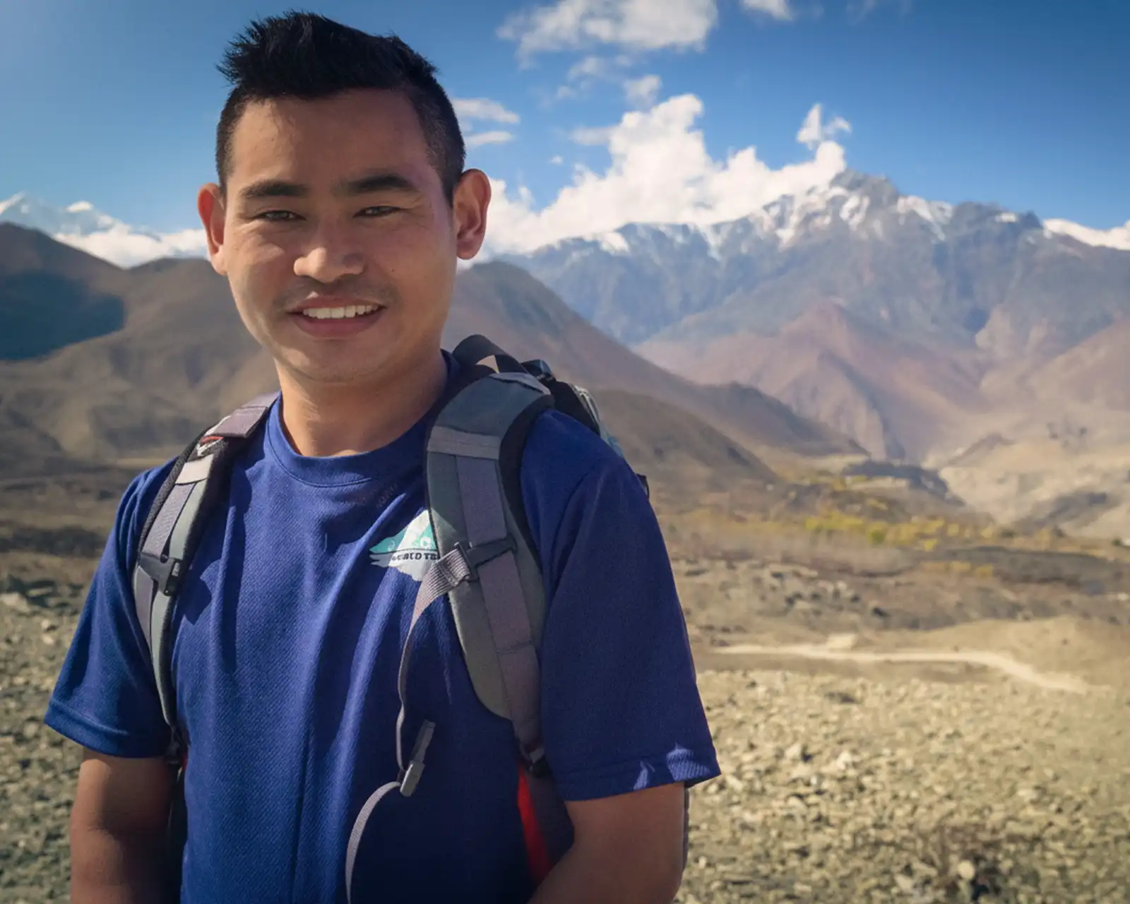 During Annapurna trek near Muktinath with clear Himalayan peaks and rocky terrain.